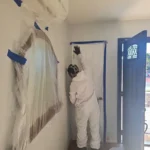 Plastic containment with a zipper door sealing a work area under negative air pressure