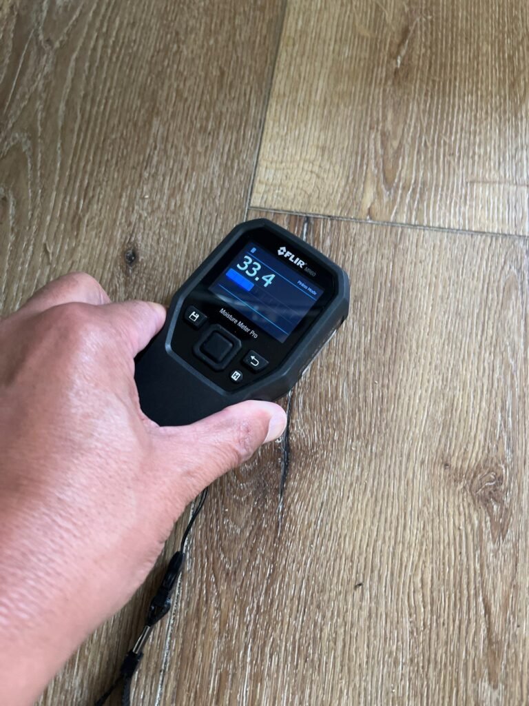 Moisture meter reading taken on a vinyl plank floor in a home