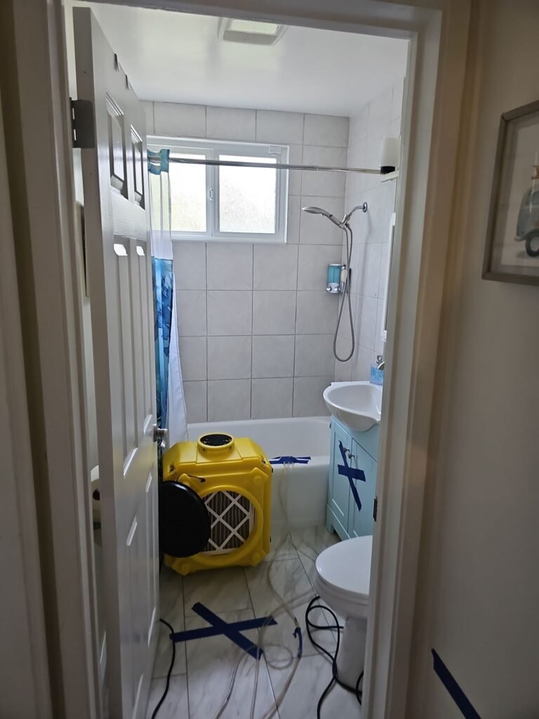 Air movers drying a bathroom after a leak
