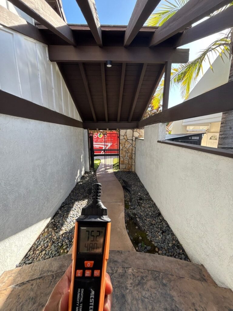 A meter held in a side passage under a pergola